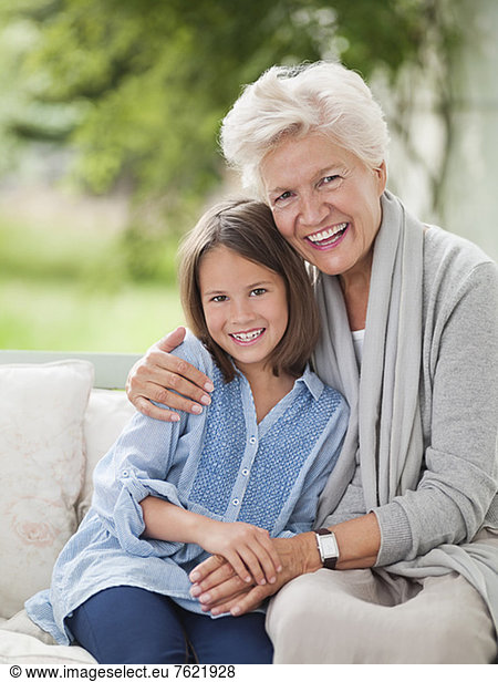 Woman and granddaughter smiling on porch swing