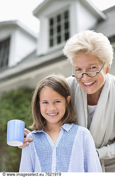 Woman and granddaughter smiling together outdoors