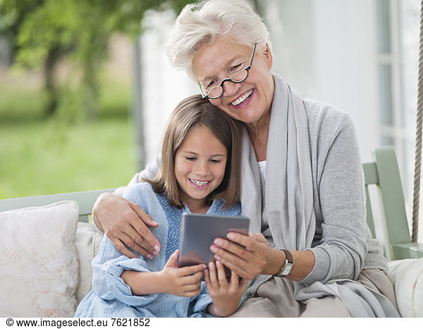 Woman and granddaughter using digital tablet