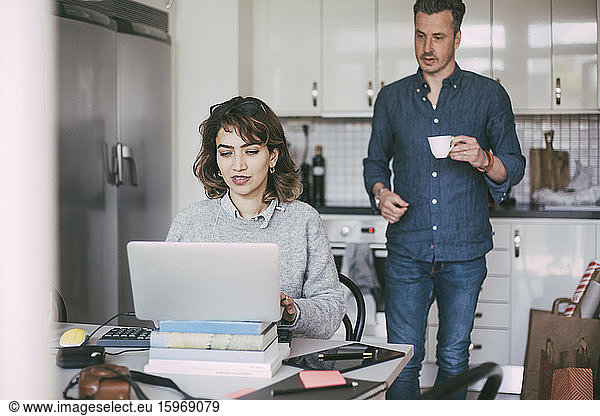 Woman and man in kitchen working at home