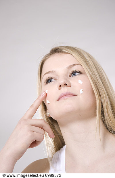 Woman Applying Skin Cream to Face