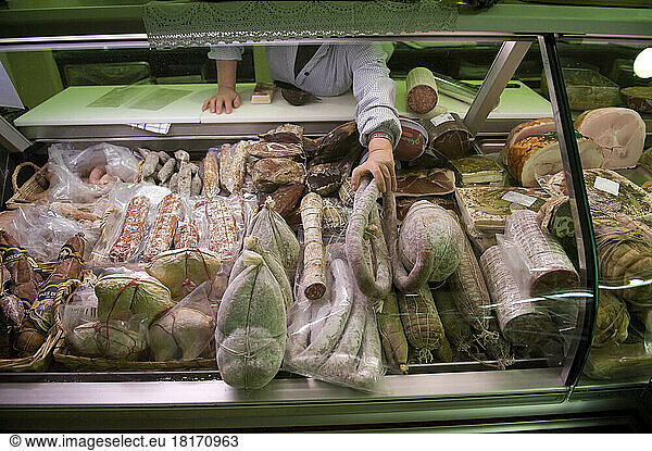 Woman arranges goods in a deli meat case in Locana  Italy; Locana  Italy