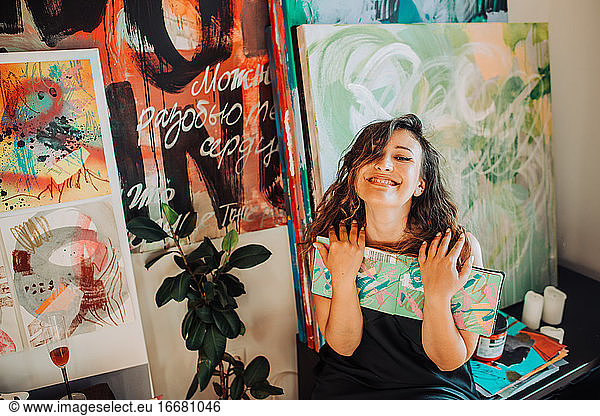 Woman artist and her art  canvas  paintings in studio