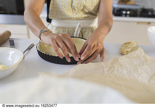 Woman baking preparing pie crust in kitchen