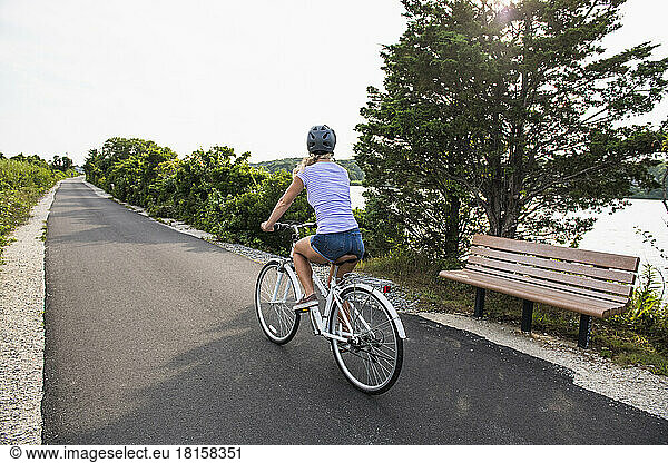 Woman biking through Cape Cod Marshes bike path