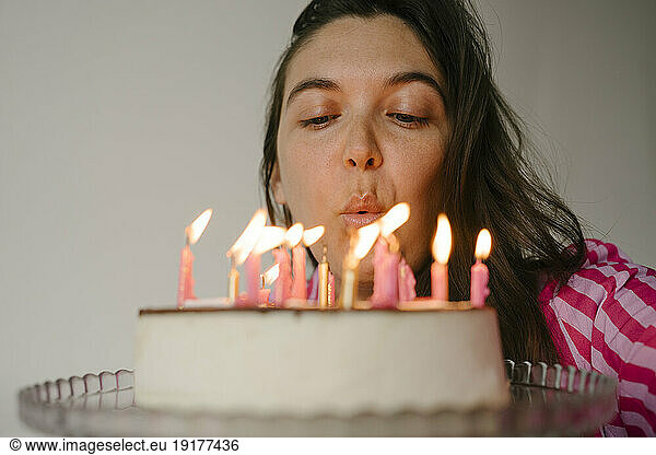 Woman blowing candles on birthday cake
