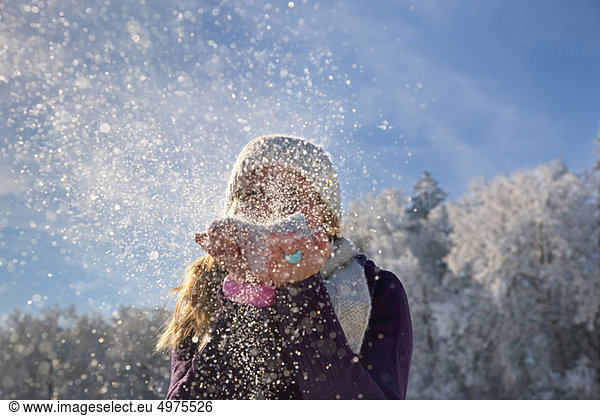 Woman blowing snow at viewer