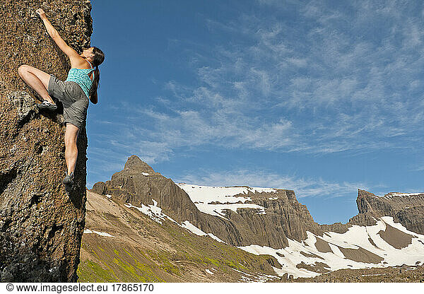 woman bouldering in the remote eastern fjords of Iceland