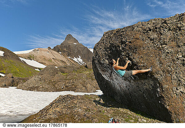 woman bouldering in the remote eastern fjords of Iceland
