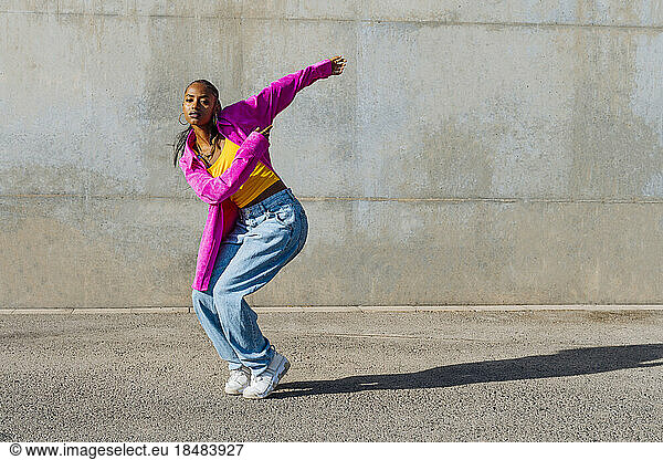 Woman breakdancing in front of wall