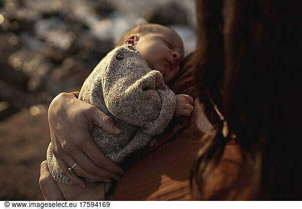 Woman carrying sleeping newborn son