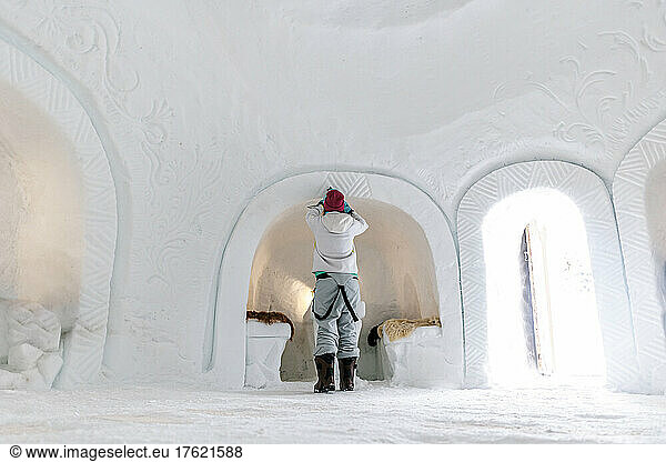 Woman carving snow in igloo