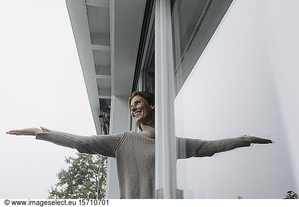 Woman checking weather, holding hand out of window