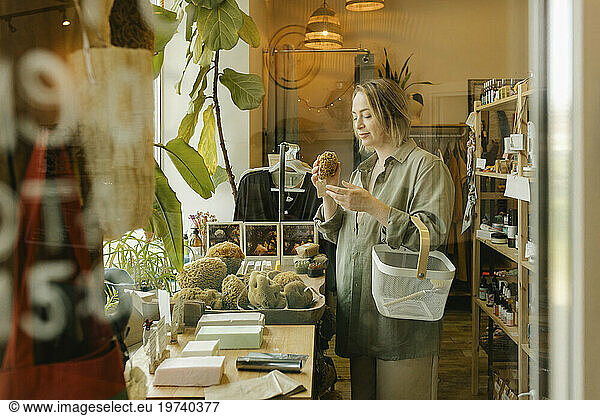 Woman choosing organic bath sponge and shopping in eco-shop