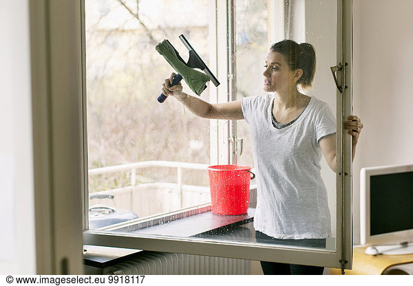 Woman cleaning glass window