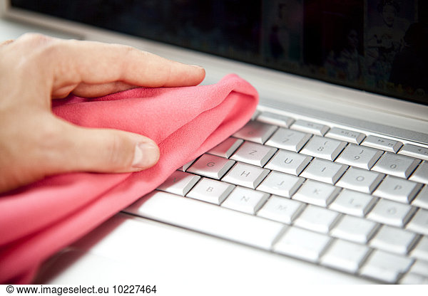 Woman cleansing laptop with duster