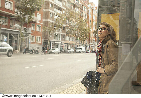 Woman contemplating at bus stop