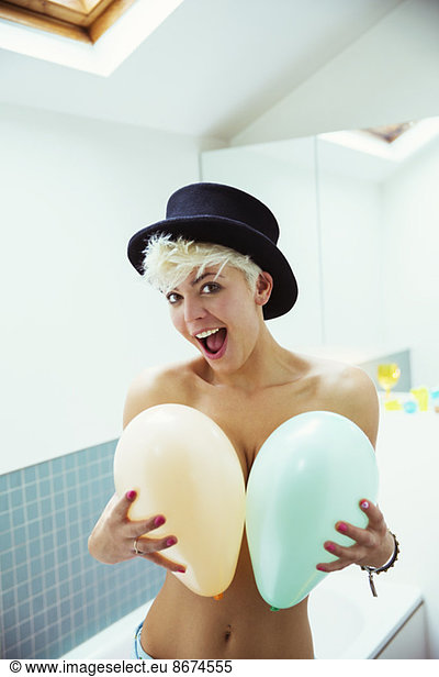 Woman covering breasts with balloons