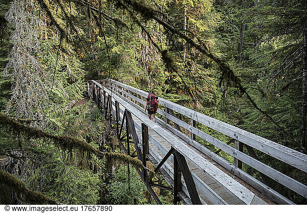 Woman crossing a bridge on the Hoh River trail