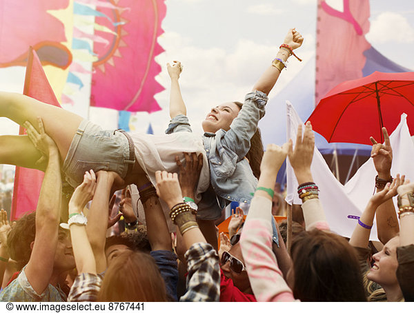 Woman crowd surfing at music festival