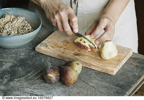 Woman Cutting Fresh Figs On Cutting Board