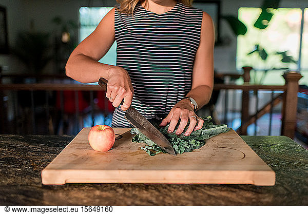 Woman cutting fresh vegetables on cutting board