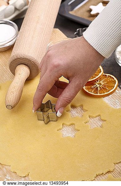Woman cutting out star-shaped cookies from cookie dough