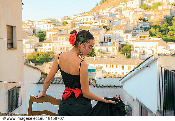 Woman dances flamenco with a Spanish town in the background