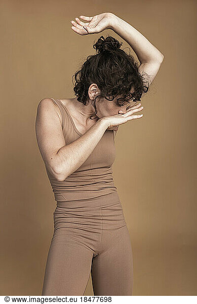 Woman dancing against brown background