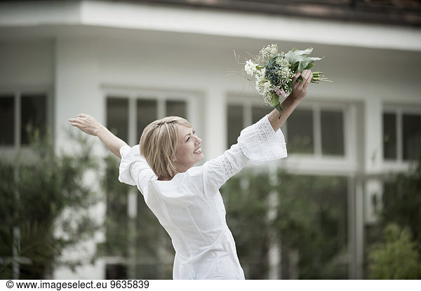 Woman dancing excited holding wedding bouquet
