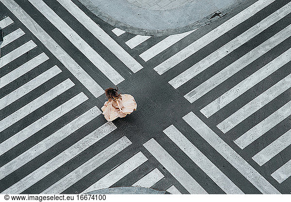 Woman dancing in a zebra crossing with a dress