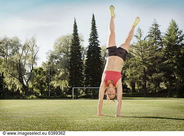 Woman doing cartwheel in park