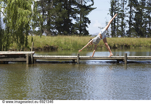 Woman Doing Cartwheel on Dock