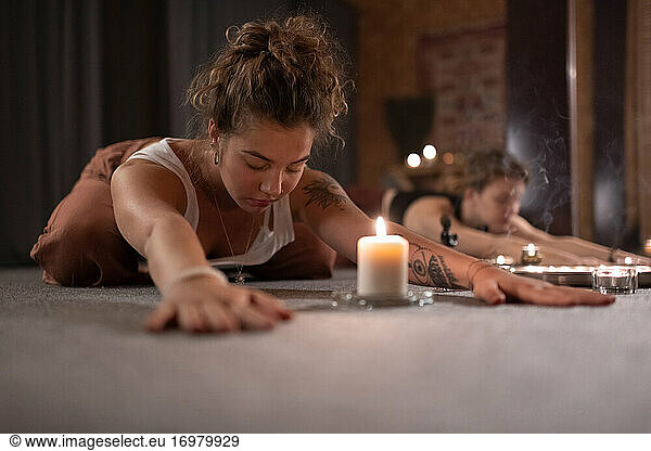 Woman doing Childs pose near candle