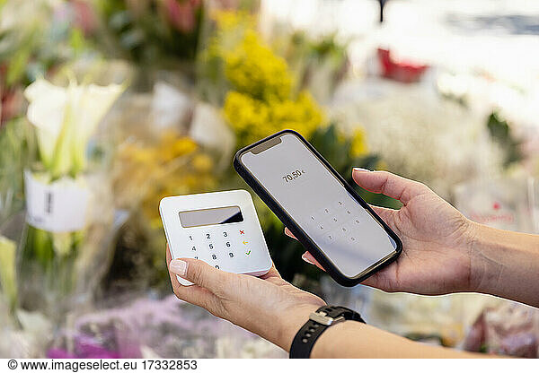 Woman doing contactless payment at flower shop