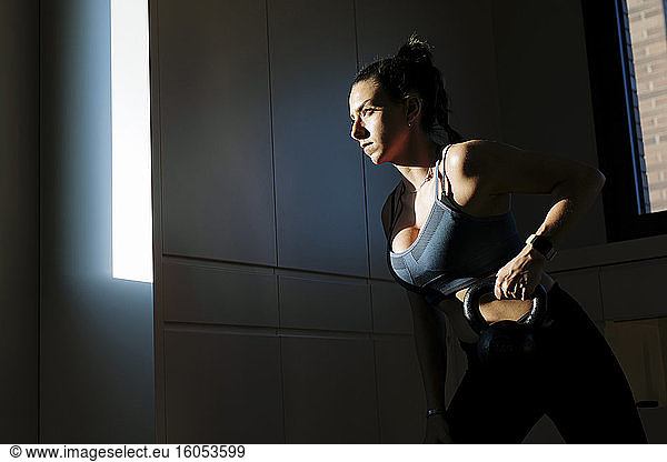 Woman doing dumbell training at home