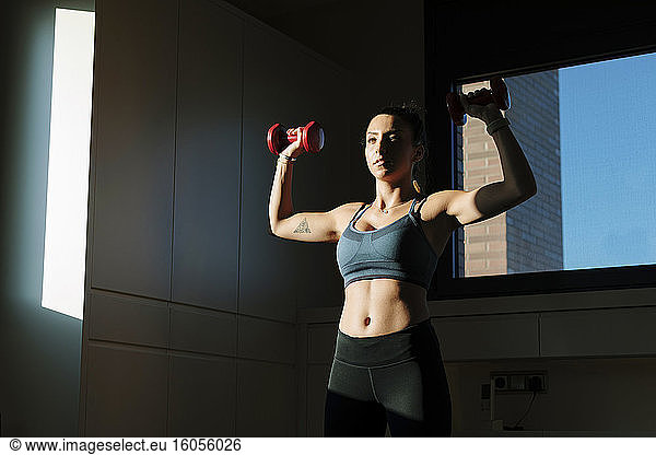 Woman doing dumbell training at home