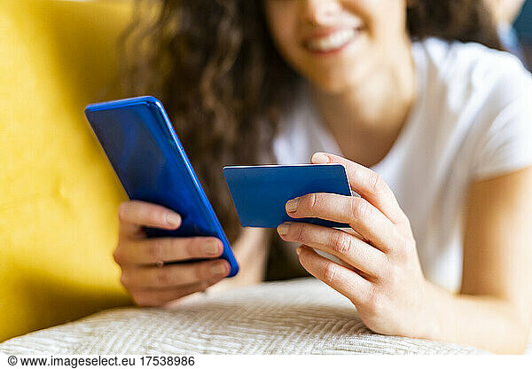 Woman doing online banking through credit card and smart phone