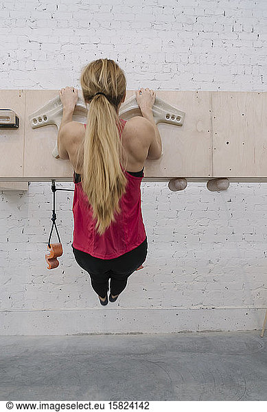 Woman doing pull-ups before climbing