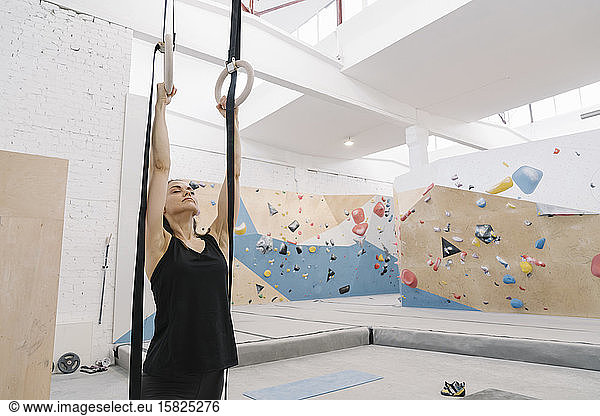 Woman doing stretching exercises before climbing on the wall