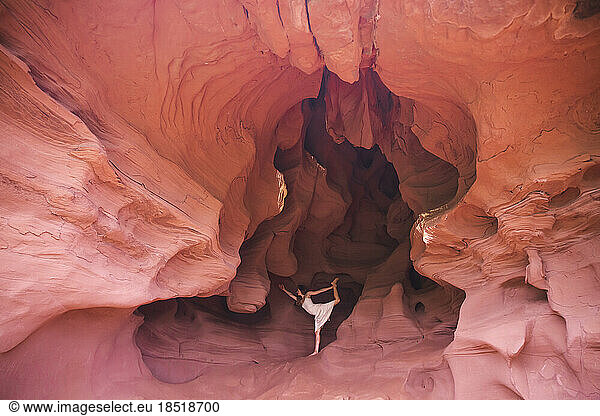 Woman doing yoga standing on one leg in cave