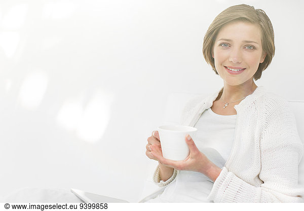 Woman drinking coffee and using digital tablet outdoors