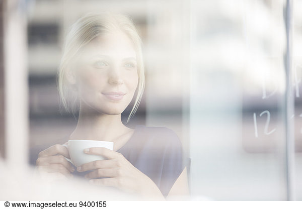 Woman drinking coffee indoors