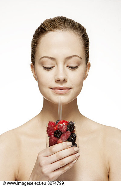 Woman drinking glass of berries