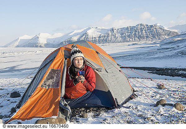 woman drinking hot beverage at winter camp in Iceland