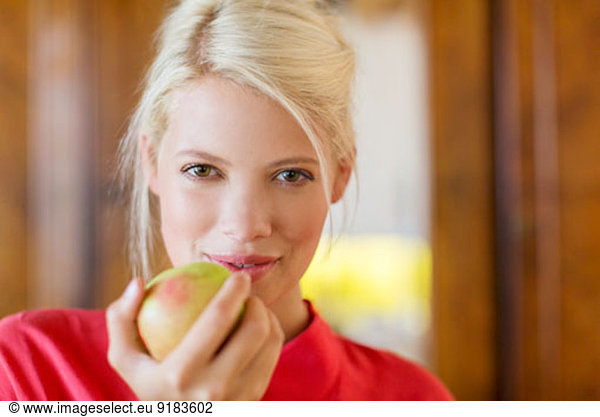 Woman eating apple indoors