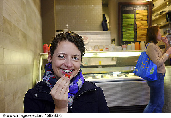 Woman eats strawberry in gelateria in Jean Talon Market