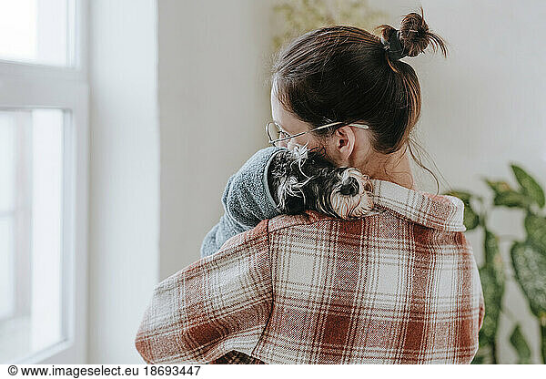 Woman embracing dog after giving bath at home