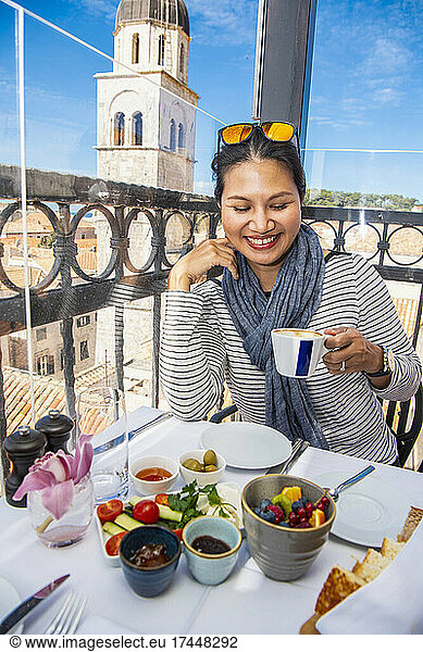 Woman enjoying coffee at restaurant in Dubrovnik