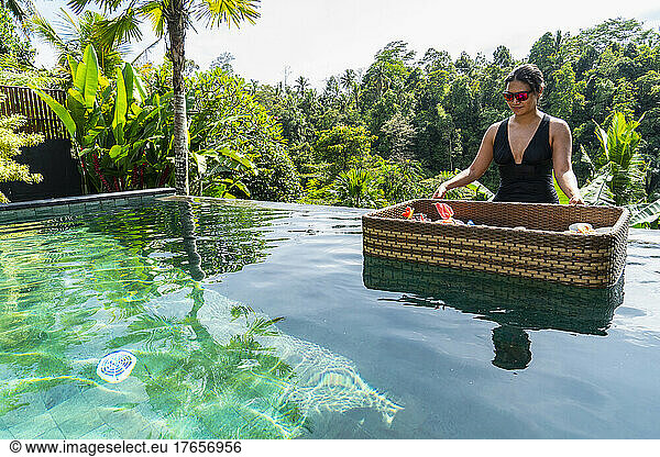 woman enjoying floating breakfast at luxury resort in Bali